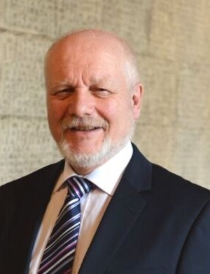 A headshot of Reinhard Strohm, smiling. 