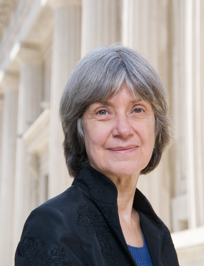 A photo of Helene P. Foley, standing before a background of classical columns. 