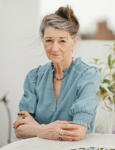 A photo of Marina Warner, sitting at a table. 