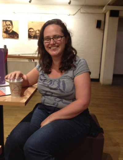 A photo of Helen Eastman sitting at a table, smiling. 