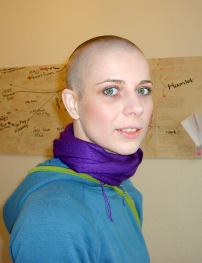 A photograph of a woman with a shaved head