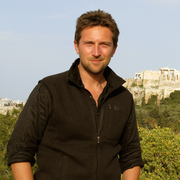 Photograph of Michael Scott with Athens ruins in the background