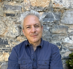 A photo of Pantelis Michelakis, standing before a rocky wall.