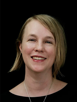 Headshot of A.E. Stallings in front of a black background